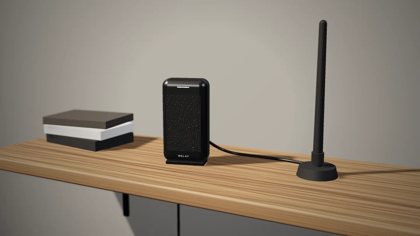 Design render of the Relay Node, a graphite box with a perforated front, on an oak wall shelf beside its external antenna